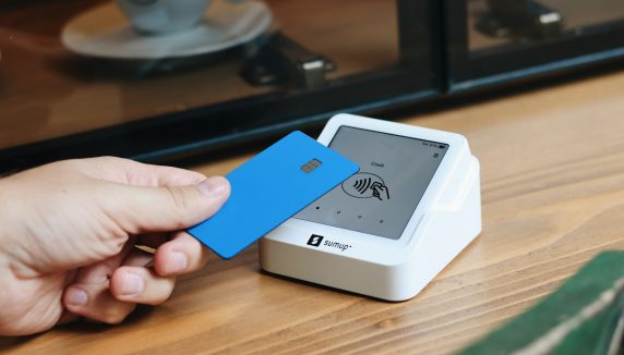 A person holding a blue card in their hand